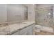 Bathroom featuring a vanity with granite countertop, framed mirror, white cabinetry, and glass-enclosed shower at 7119 Falabella Ridge Ave, Las Vegas, NV 89131