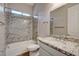 Granite shower, vanity countertop, white cabinetry and fixtures in this bright bathroom create a clean and polished look at 7119 Falabella Ridge Ave, Las Vegas, NV 89131