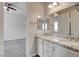 Bright bathroom featuring dual sinks, white cabinetry, and granite countertops, with a doorway leading to the bedroom at 7119 Falabella Ridge Ave, Las Vegas, NV 89131