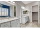 Bathroom featuring granite countertops, dual sinks, ample lighting, and convenient access to a walk-in closet at 7119 Falabella Ridge Ave, Las Vegas, NV 89131