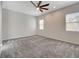 A large bedroom offers neutral carpet, large windows and contemporary ceiling fan at 7119 Falabella Ridge Ave, Las Vegas, NV 89131