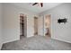 This bedroom features plush carpeting, a ceiling fan, and multiple doorways for convenience and accessibility at 7119 Falabella Ridge Ave, Las Vegas, NV 89131