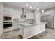 Modern kitchen boasts stainless steel appliances, a spacious island, and stylish gray wood flooring at 7119 Falabella Ridge Ave, Las Vegas, NV 89131