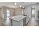 This kitchen offers a granite countertop island, stainless steel appliances, and backyard views at 7119 Falabella Ridge Ave, Las Vegas, NV 89131