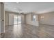 Open living room with wood tile floors and sliding doors to the pool area at 7119 Falabella Ridge Ave, Las Vegas, NV 89131