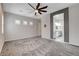 Spacious main bedroom featuring plush carpeting, ceiling fan, and ensuite bathroom entrance at 7119 Falabella Ridge Ave, Las Vegas, NV 89131