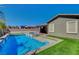 Backyard featuring a sparkling pool with raised spa, artificial turf, and a covered patio for outdoor living at 7119 Falabella Ridge Ave, Las Vegas, NV 89131