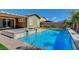 A backyard pool with a spa, patio area, and palm trees at 7119 Falabella Ridge Ave, Las Vegas, NV 89131