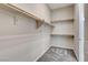 Walk-in closet providing ample storage with wooden shelving and rods and carpeted floor at 7119 Falabella Ridge Ave, Las Vegas, NV 89131