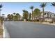 Community entrance featuring a sign, landscaping, palm trees, and a security gate at 7255 W Sunset Rd # 2021, Las Vegas, NV 89113