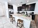 Modern kitchen featuring dark cabinets, granite countertops, stainless steel appliances, and a convenient breakfast bar at 760 Crisp Morning Ct, North Las Vegas, NV 89086