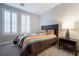 Well-lit bedroom featuring a decorative bed, striped quilt, neutral carpet, and white window shutters at 9568 Bloodstone Ln, Las Vegas, NV 89143