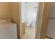 Functional bathroom with white toilet, pedestal sink, laundry area, and neutral paint at 9935 Swimming Hole St, Las Vegas, NV 89183