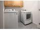 Convenient laundry room featuring a modern washer and dryer, complemented by storage cabinets above at 10009 Locking Biner Ave, Las Vegas, NV 89166
