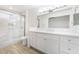 Bathroom featuring dual sinks, updated lighting, tile floors, and a glass shower at 10041 Arbuckle Dr, Las Vegas, NV 89134