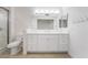 Bathroom featuring dual sinks, updated lighting, tile floors, and a glass shower at 10041 Arbuckle Dr, Las Vegas, NV 89134