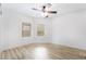 Bright bedroom featuring wood-look flooring, a ceiling fan, and windows with white trim at 10041 Arbuckle Dr, Las Vegas, NV 89134