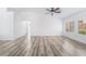 Large living room with wood-look flooring, ceiling fan, and plenty of natural light at 10041 Arbuckle Dr, Las Vegas, NV 89134