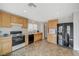 Eat-in kitchen with black appliances, wood cabinets, tile flooring, and recessed lights at 10265 Franford Ct, Las Vegas, NV 89183