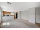 Open floor plan living room features neutral carpet and is open to the kitchen with black appliances at 10265 Franford Ct, Las Vegas, NV 89183