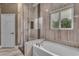 Contemporary bathroom with a sleek glass shower, a separate tub, and a bright window at 10705 Arundel Ave, Las Vegas, NV 89135