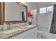 Bright bathroom with a granite countertop vanity, framed mirror, and a shower-over-tub combination at 10705 Arundel Ave, Las Vegas, NV 89135