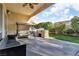 Covered patio with a ceiling fan, outdoor seating, built-in grill, and landscaping at 10705 Arundel Ave, Las Vegas, NV 89135