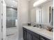 Well-lit bathroom featuring a glass enclosed shower/tub, vanity with marble countertop and sleek design at 12 Olympia Chase Dr, Las Vegas, NV 89141