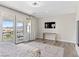 Spacious bedroom with doors to a balcony, a view and a mounted TV at 12 Olympia Chase Dr, Las Vegas, NV 89141