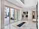 Bright entryway featuring marble floors and glass doors that open to an outdoor space, with a modern kitchen in the background at 12 Olympia Chase Dr, Las Vegas, NV 89141