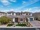 An elegant two-story home featuring a stone facade, well-manicured landscaping, and a three-car garage at 12 Olympia Chase Dr, Las Vegas, NV 89141