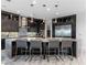 Modern kitchen with dark cabinetry, stainless steel appliances, a large center island, and stylish bar stools at 12 Olympia Chase Dr, Las Vegas, NV 89141