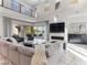 Open-concept living room with a comfortable gray couch, a fireplace, and expansive views at 12 Olympia Chase Dr, Las Vegas, NV 89141