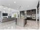 Bright, open living area with a modern kitchen, fireplace, and ample seating, featuring large windows for natural light at 12 Olympia Chase Dr, Las Vegas, NV 89141