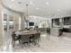 Open-concept living space featuring elegant marble floors, modern lighting, and seamless connection to the kitchen and outdoor views at 12 Olympia Chase Dr, Las Vegas, NV 89141