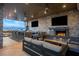 Luxurious outdoor living space featuring a full kitchen, fireplace, TVs, and seating area with city views at 12 Olympia Chase Dr, Las Vegas, NV 89141