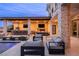 Outdoor living space with an outdoor kitchen, bar seating, fireplace, and comfortable seating for relaxation and entertaining at 12 Olympia Chase Dr, Las Vegas, NV 89141