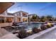 A stunning pool with water features complements a modern two-story home and outdoor lounge at 12 Olympia Chase Dr, Las Vegas, NV 89141