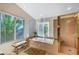 Bright bathroom features a soaking tub, a glass-enclosed shower, and natural light from the windows at 1353 Volturno Way, Henderson, NV 89052