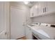 Convenient laundry room with washer, dryer, and overhead storage cabinets at 1404 Dragon Rock Dr, Henderson, NV 89052