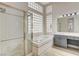 Bright bathroom featuring a soaking tub, tiled shower, and a double vanity sink at 1700 Wandering Winds Way, Las Vegas, NV 89128