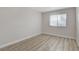 Bedroom with wood-look flooring and bright, natural light from the window at 1700 Wandering Winds Way, Las Vegas, NV 89128