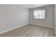A minimalist bedroom with light wood-look floors and a window with blinds at 1700 Wandering Winds Way, Las Vegas, NV 89128