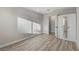 Bright bedroom featuring light wood-look floors and mirrored closet doors at 1700 Wandering Winds Way, Las Vegas, NV 89128