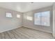 Bright bedroom featuring light wood-look floors, neutral paint, and multiple windows at 1700 Wandering Winds Way, Las Vegas, NV 89128