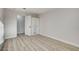 Bright bedroom featuring light wood-look floors and mirrored closet doors at 1700 Wandering Winds Way, Las Vegas, NV 89128