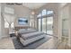 Light-filled bedroom with a large window, ceiling fan, and access to an en-suite bathroom at 1700 Wandering Winds Way, Las Vegas, NV 89128