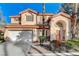 Two-story home with a tile roof, a two-car garage, and manicured landscaping at 1700 Wandering Winds Way, Las Vegas, NV 89128
