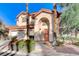 Inviting two-story home with an arched entryway and mature landscaping at 1700 Wandering Winds Way, Las Vegas, NV 89128