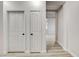 Hallway with two doors and a view into another room with light wood flooring at 1700 Wandering Winds Way, Las Vegas, NV 89128